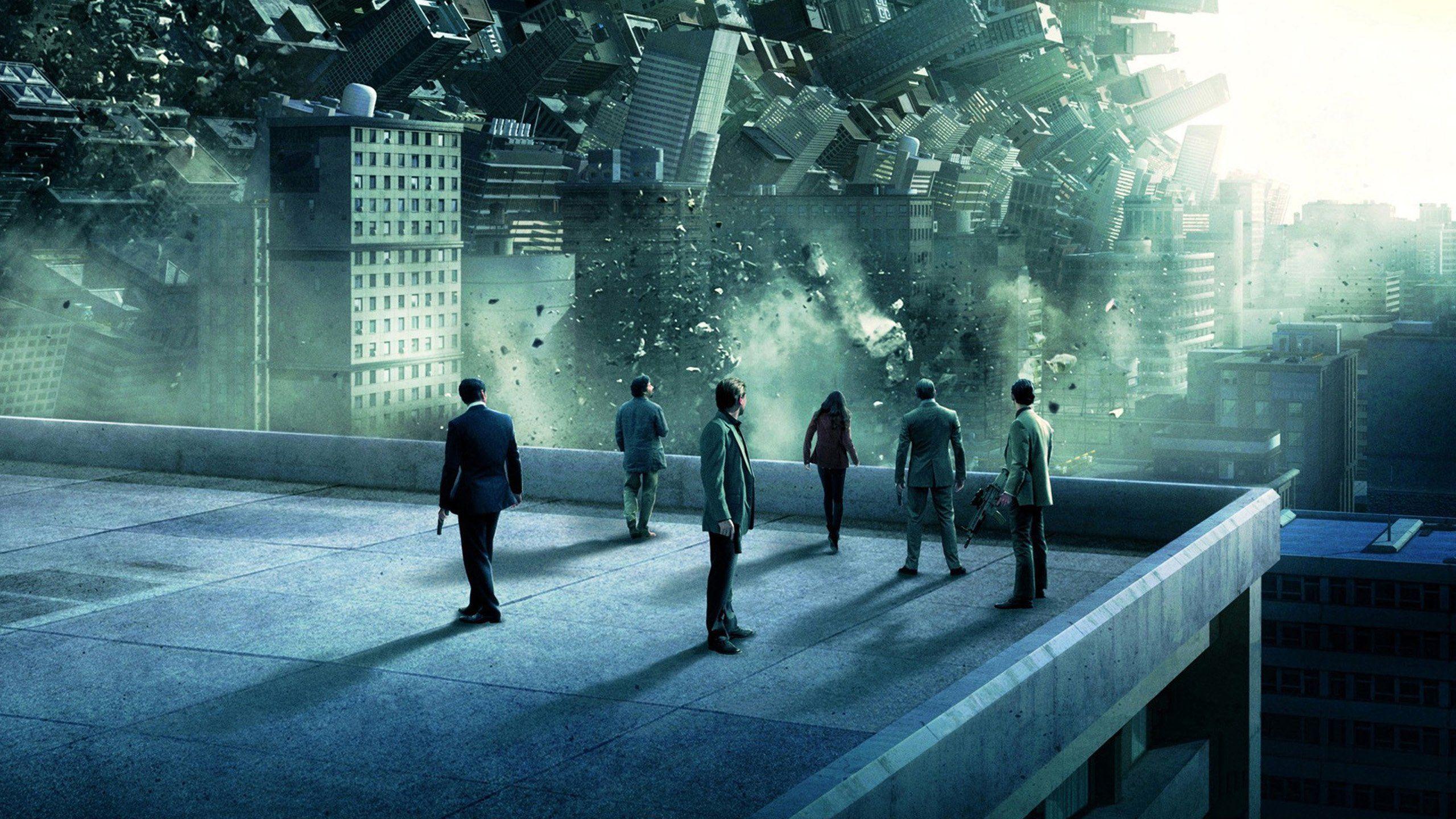 cover of inception movie. group of people looking at collapsing buildings